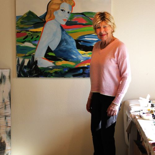 Ein Foto der Künstlerin Karin Beck, vor einem ihrer Werke stehend